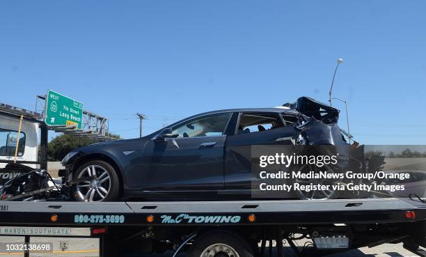 Damaged Tesla sits on a tow truck after a collision in the HOV lane on the northbound 405/22 Freeway in Seal Beach after a fatal traffic accident on...