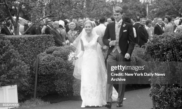 Tricia and Ed Cox walk arm in arm after history's first Rose Garden wedding at the White House yesterday. The ceremony was delayed about a half hour...