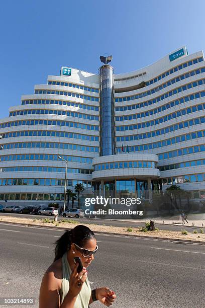 Woman holds a mobile device outside the headquarters of Portugal Telecom SGPS SA 's mobile unit, Telecomunicacoes Moveis Nacionais , in Lisbon,...