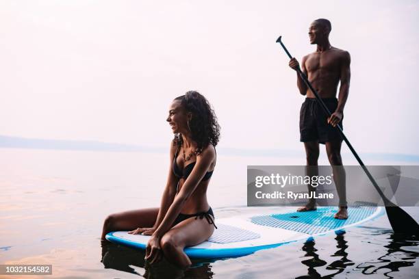 young couple paddleboarding puget sound in summer - paddle surf stock pictures, royalty-free photos & images