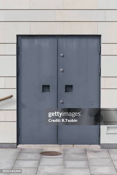 heavy dark metal door on modern stone wall - five cent coin stock pictures, royalty-free photos & images