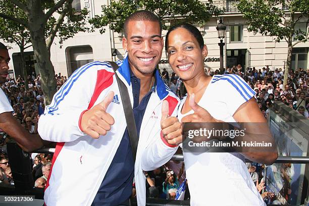 French athletes Benjamin Compaore and Christine Arron pose as they leave the official sponsor store Adidas on the Champs Elysees avenue in Paris, on...