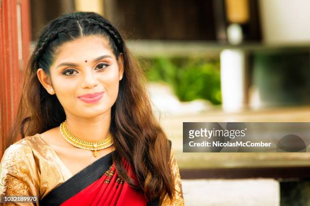 beautiful indian female with soft smile close-up portrait sitting in stairway - gold sari imagens e fotografias de stock