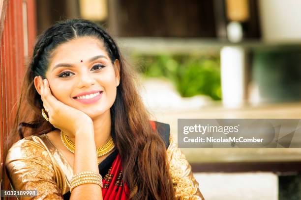 beautiful indian female with portrait sitting in stairway - gold sari imagens e fotografias de stock