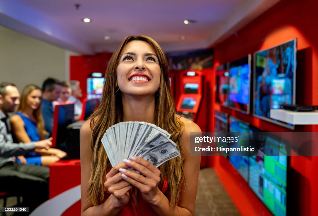 Hermosa mujer de América Latina con un montón de dinero ganar en el casino buscando soñar despierto