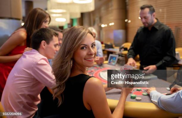 笑みを浮かべてカメラを見ている間ブラック ジャックのテーブルで勝利のカードを保持している美しい女性の肖像画 - casino worker ストックフォトと画像
