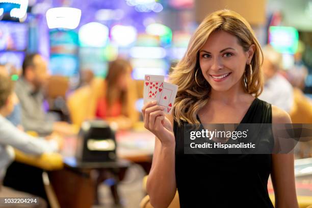 goegrous latijns-amerikaanse vrouw met een aas en een tien terwijl kijken naar camera glimlachen - casino table games stockfoto's en -beelden