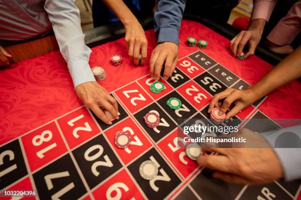 close up of unrecognizable people placing bets on table of roulette - (position) stock pictures, royalty-free photos & images