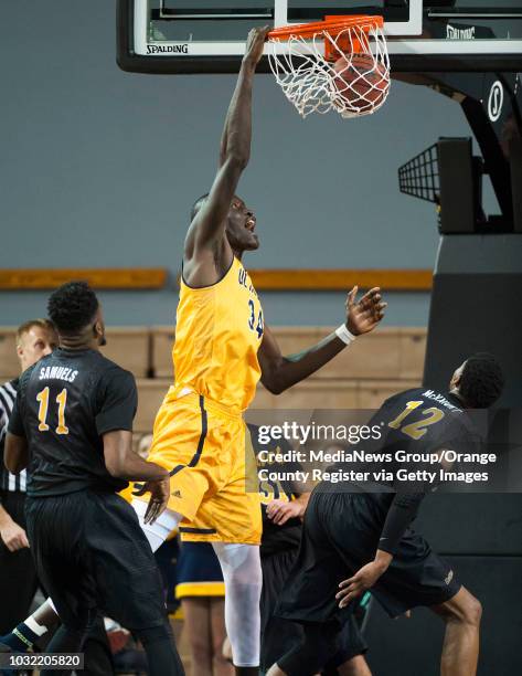 Irvine's Mamadou Ndiaye dunks over Long Beach State's David Samuels, left, and Eric McKnight during the first half of their basketball game at the...