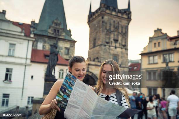 young women standing on the charles bridge and exploring the city with city map - prague stock pictures, royalty-free photos & images