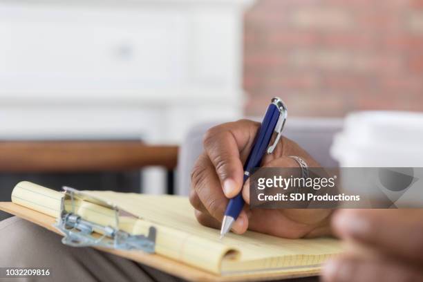 closeup of unrecognizable person writing on clipboard - thumb ring stock pictures, royalty-free photos & images