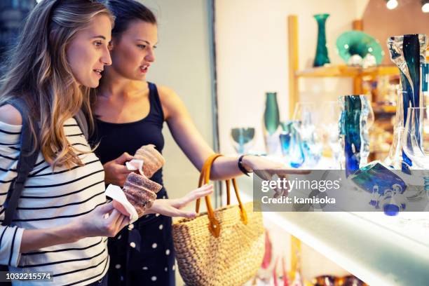 young women go shopping in the city - holding in their hands trdelnik (traditional czech hot sweet pastry) - trdelník stock pictures, royalty-free photos & images