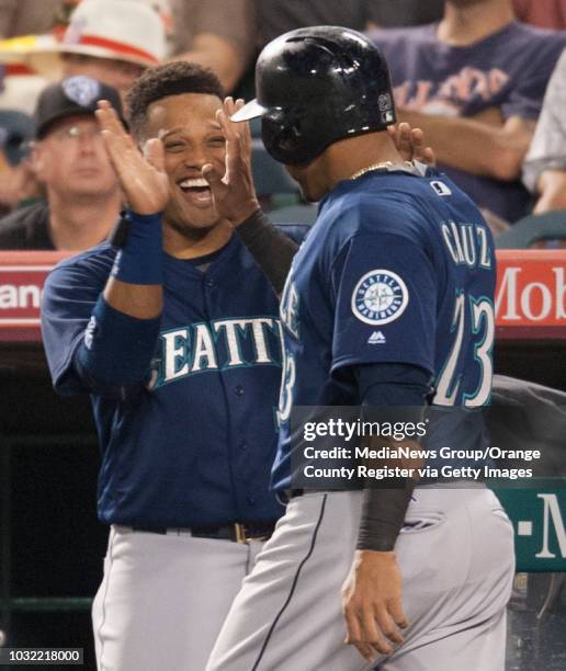 The Mariners' Robinson Cano welcomes Nelson Cruz into the dugout after his solo home run in the fifth inning off of Angels' starter Ricky Nolasco at...