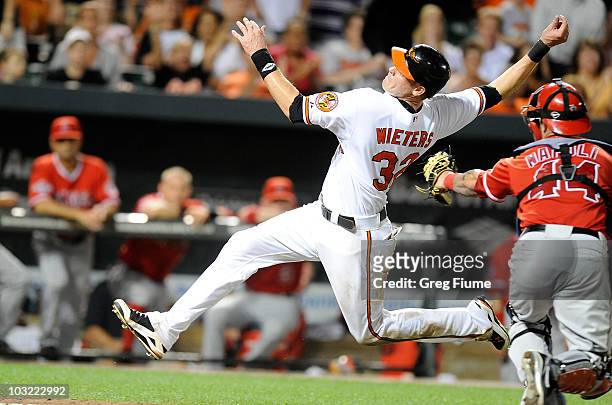 Matt Wieters of the Baltimore Orioles tries to avoid the tag of Mike Napoli of the Los Angeles Angels of Anaheim at Camden Yards on August 3, 2010 in...