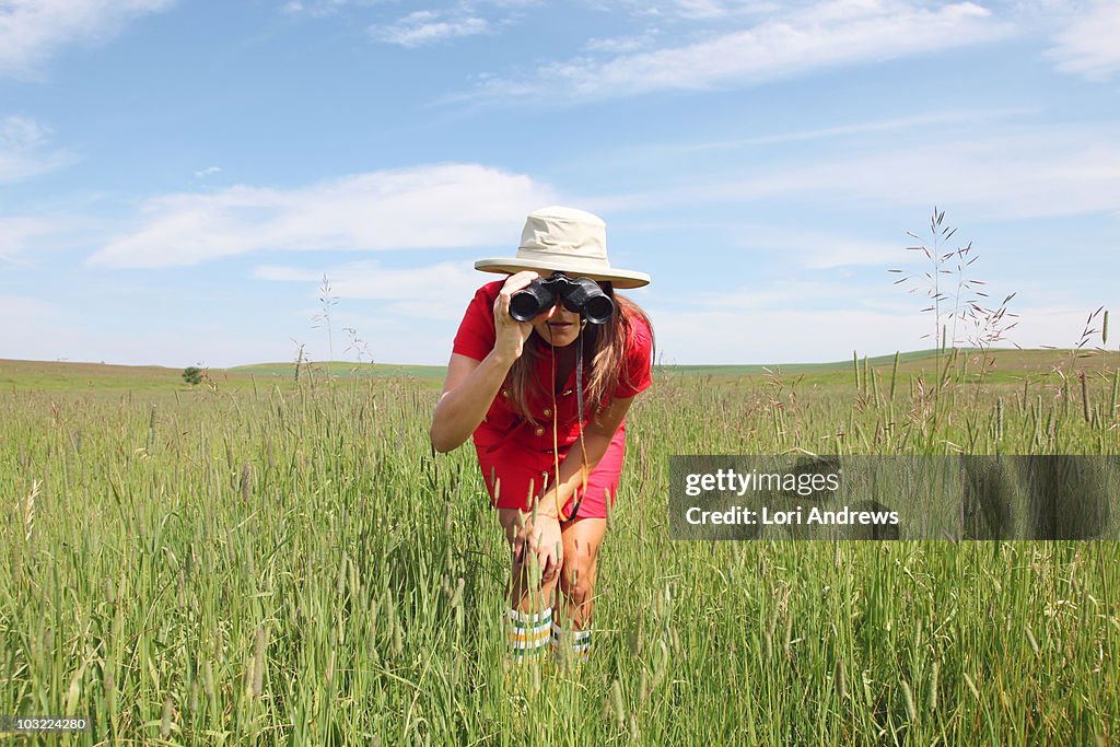 Woman with binoculars in field