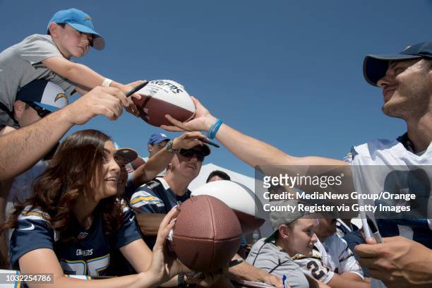 Gavin Bermudez of Long Beach, gets an autograph from punter Drew Kaser over the head of Maritza Palacios of Santa Ana, after the Chargers' training...