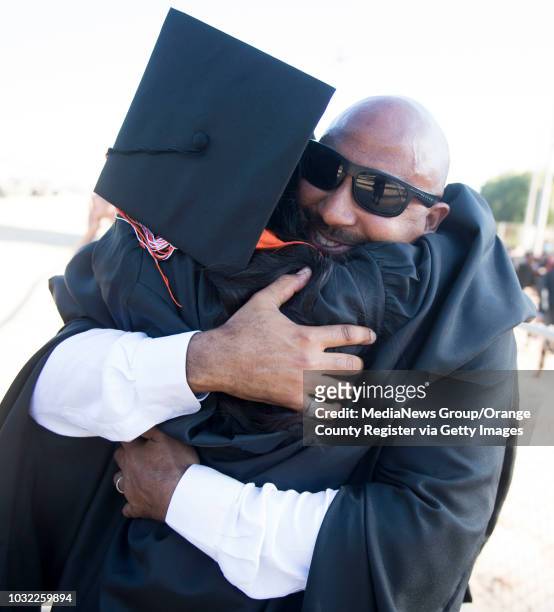 Senior Class Assistant Principal Jared Fulton gives graduate Laura Valdez a hug, as he does for every student, after the Los Amigos High School...