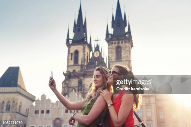 girlfriends taking selfies in front of tyn church in prague - prague people stock pictures, royalty-free photos & images