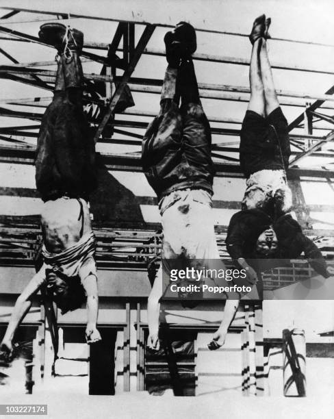 The corpse of Italian fascist leader Benito Mussolini hangs by his feet at a petrol station in Milan, after his execution by partisans at Mezzegra,...