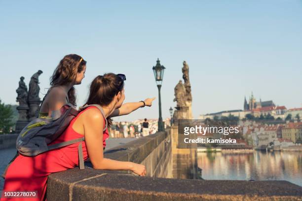 female tourists enjoying the view from the charles bridge in prague - prague tourist stock pictures, royalty-free photos & images