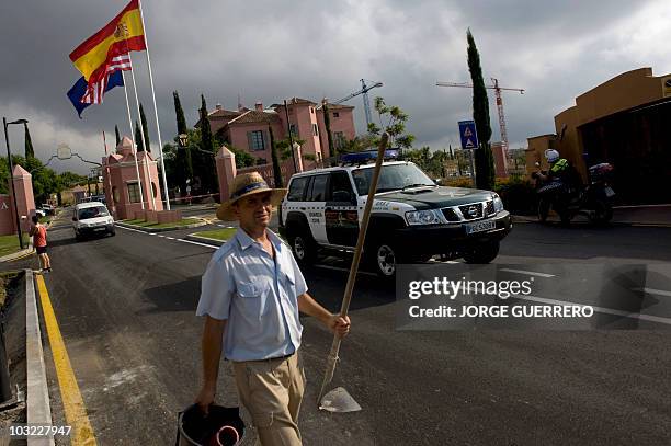 Construction workers walks by a Spanish Civil Guard at the entrance of the hotel Villa Padierna, where US First Lady Michelle Obama arrived for her...