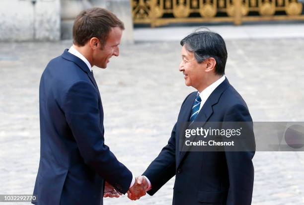 French President Emmanuel Macron welcomes Japan's Crown Prince Naruhito prior to their meeting at the Chateau de Versailles on September 12, 2018 in...