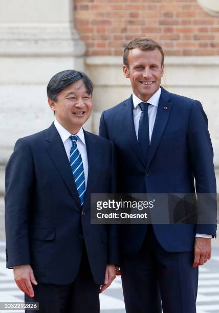 French President Emmanuel Macron welcomes Japan's Crown Prince Naruhito prior to their meeting at the Chateau de Versailles on September 12, 2018 in...