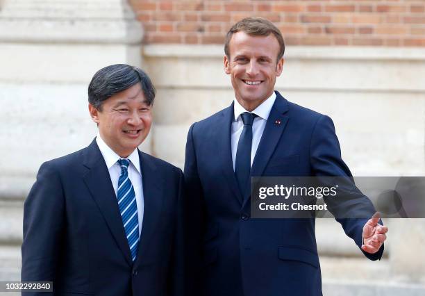 French President Emmanuel Macron welcomes Japan's Crown Prince Naruhito prior to their meeting at the Chateau de Versailles on September 12, 2018 in...