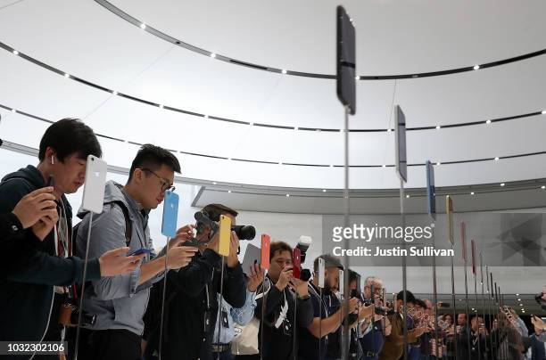 Visitors inspect the new iPhone XR during an Apple special event at the Steve Jobs Theatre on September 12, 2018 in Cupertino, California. Apple...