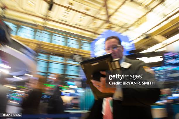 Traders work on the floor at the closing bell of the Dow Industrial Average at the New York Stock Exchange on September 12, 2018 in New York. - Wall...