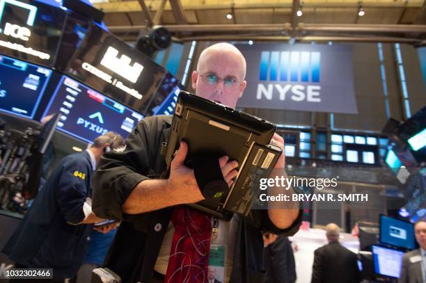 Traders work on the floor at the closing bell of the Dow Industrial Average at the New York Stock Exchange on September 12, 2018 in New York. - Wall...