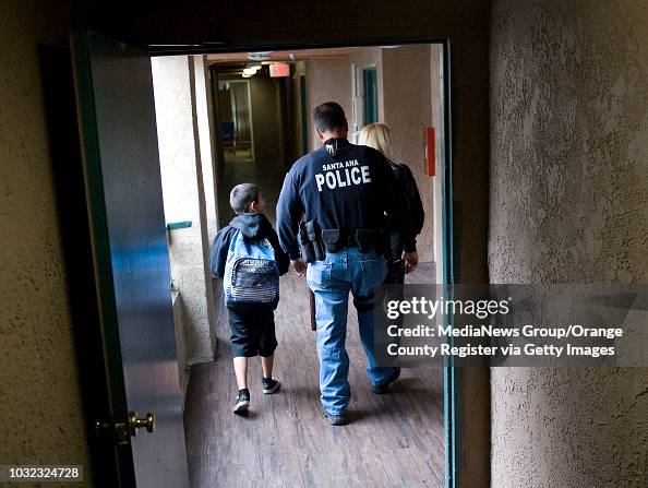 Santa Ana Police Det. Eric Rivas escorts a student to his car for a ...