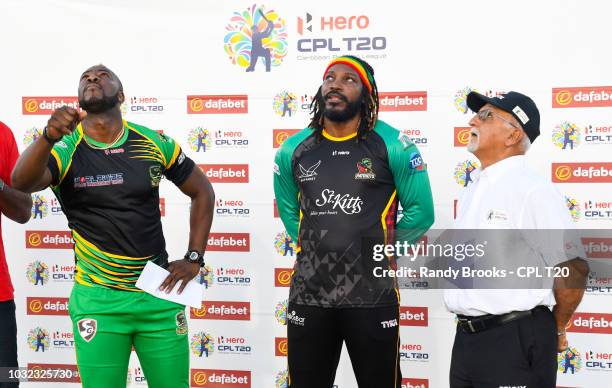 In this handout image provided by CPL T20, Andre Russell of Jamaica Tallawahs toss the coin as Chris Gayle of St Kitts & Nevis Patriots and match...