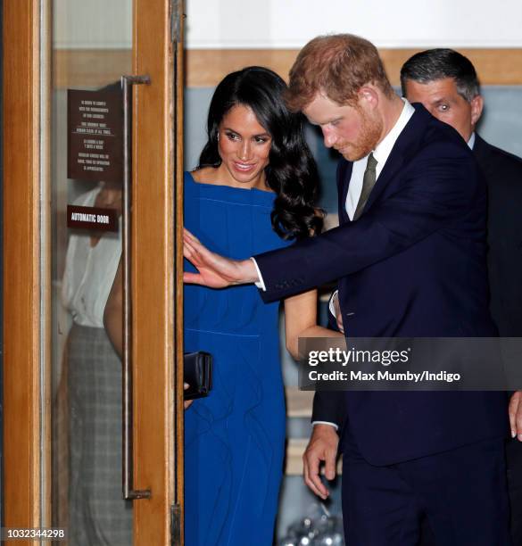 Prince Harry, Duke of Sussex holds open the door for Meghan, Duchess of Sussex as they depart the "100 Days of Peace" concert to commemorate the...