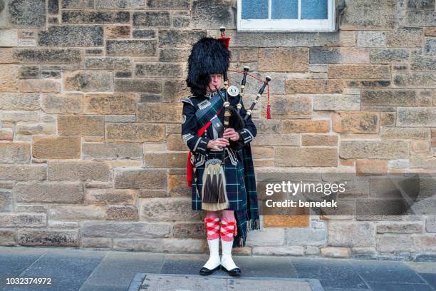 scottish piper mit dudelsack auf der royal mile in edinburgh schottland, vereinigtes königreich - bagpipes stock-fotos und bilder