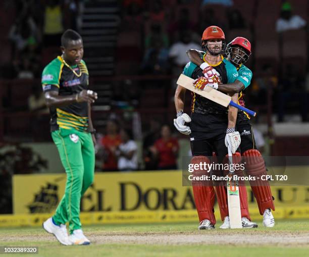 In this handout image provided by CPL T20, Ben Cutting and Hayden Walsh Jr. Of St Kitts & Nevis Patriots celebrate as Rovman Powell of Jamaica...