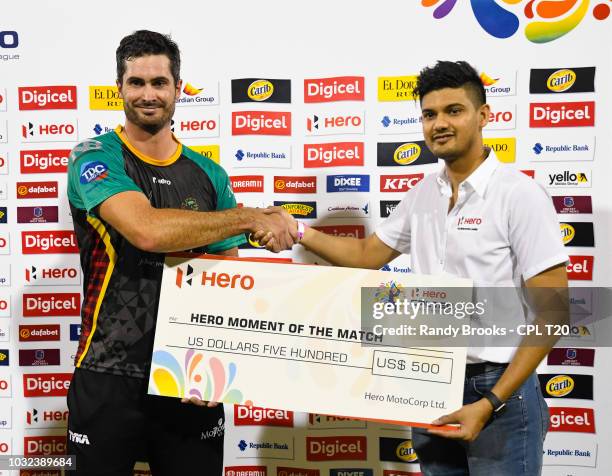 In this handout image provided by CPL T20, Ben Cutting of St Kitts & Nevis Patriots receives the Hero moment of the match prize from Joshua Ramdehol...