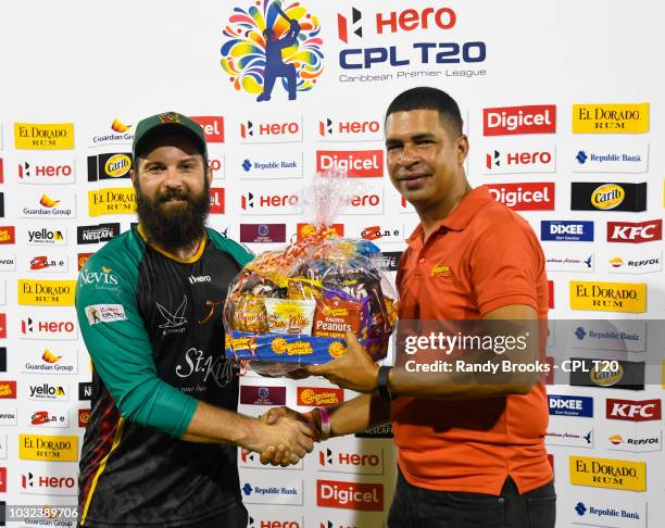 In this handout image provided by CPL T20, Anton Devchich of St Kitts & Nevis Patriots receives the Sunshine Snacks prize from Jeranzee Marques of...