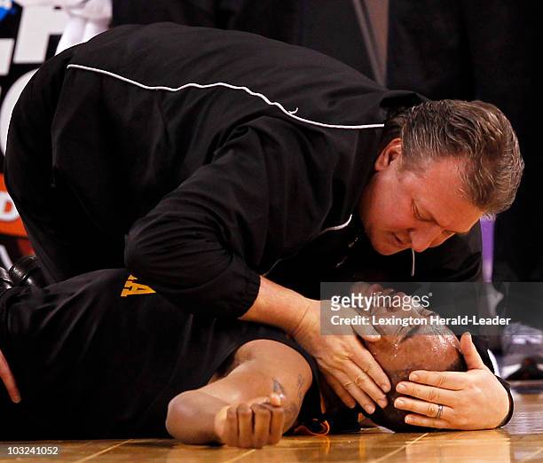 West Virginia head coach Bob Huggins tries to comfort Da'Sean Butler of West Virginia after he was hurt during the second half in an NCAA Final Four...