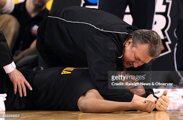 West Virginia head coach Bob Huggins comforts Da'Sean Butler of West Virginia after he was injured during the second half of play against Duke in an...