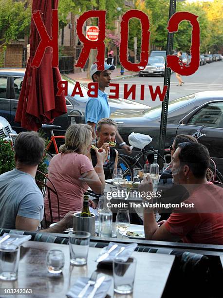 Customers enjoy outside tables at the CORK Wine Bar along the 14th Street corridor on July 27, 2010.