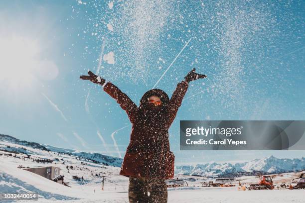 young woman in winter clothes playing with snow - face snow stockfoto's en -beelden