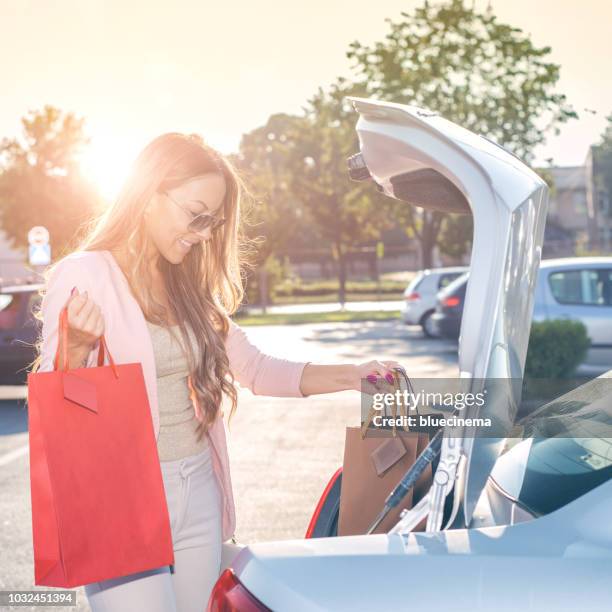 woman putting shopping bags in the car - square one mall stock pictures, royalty-free photos & images