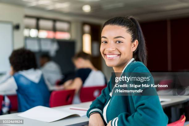 portrait of happy student at desk in classroom - female high school student stock pictures, royalty-free photos & images