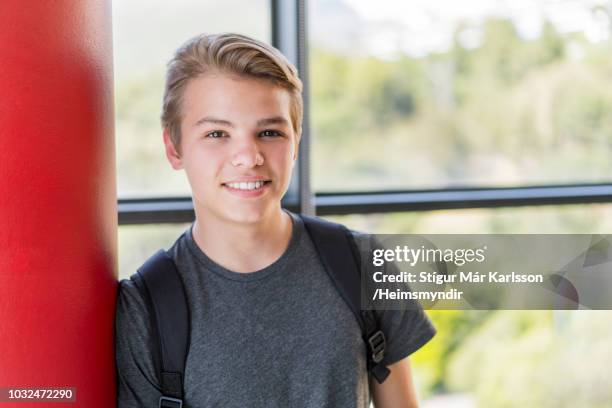 smiling male student leaning on column in school - school boy with bag stock pictures, royalty-free photos & images