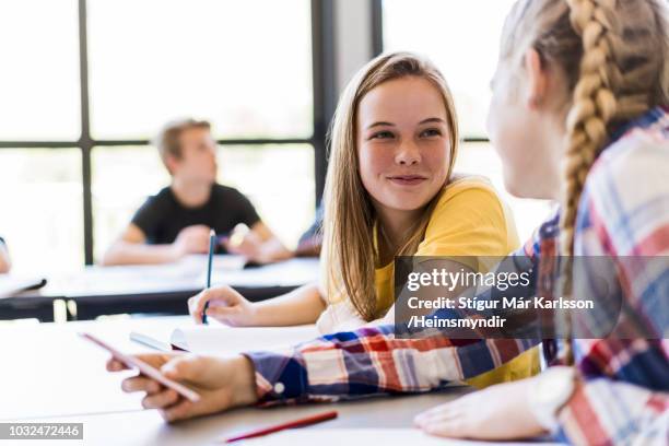 female friends talking in classroom - students talking stock pictures, royalty-free photos & images