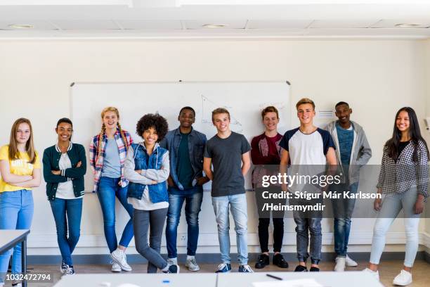 schülerinnen und schüler im klassenzimmer stehen lächelnd - school boy girl stock-fotos und bilder