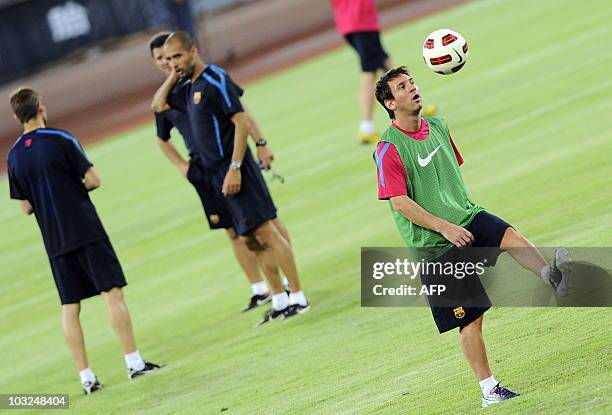 Barcelona's Argentinian midfielder Lionel Messi eyes the ball while juggling during a light training session with teammates and coaches at the...