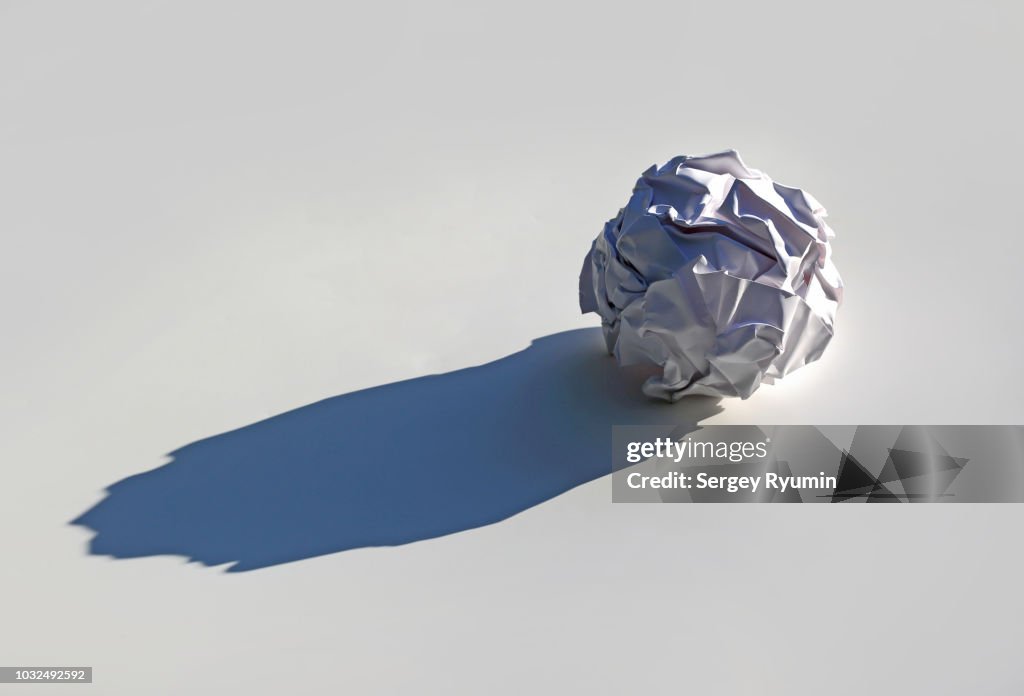 Crumpled paper ball with a shadow