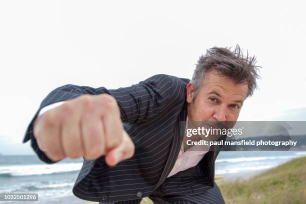 middle aged man in suit throwing punch at camera - freedom fighter stock pictures, royalty-free photos & images